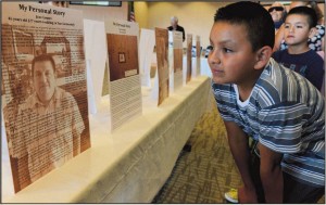 Dionisio Gomez, 10, and his brother Allan, 7, look at their father’s biography in an exhibit at Our Lady of Fatima Catholic Church on generations of families who migrated from El Bajio, Mexico, to San Clemente. About 1,500 of San Clemente’s 64,000 residents can be traced to this multigenerational migration.